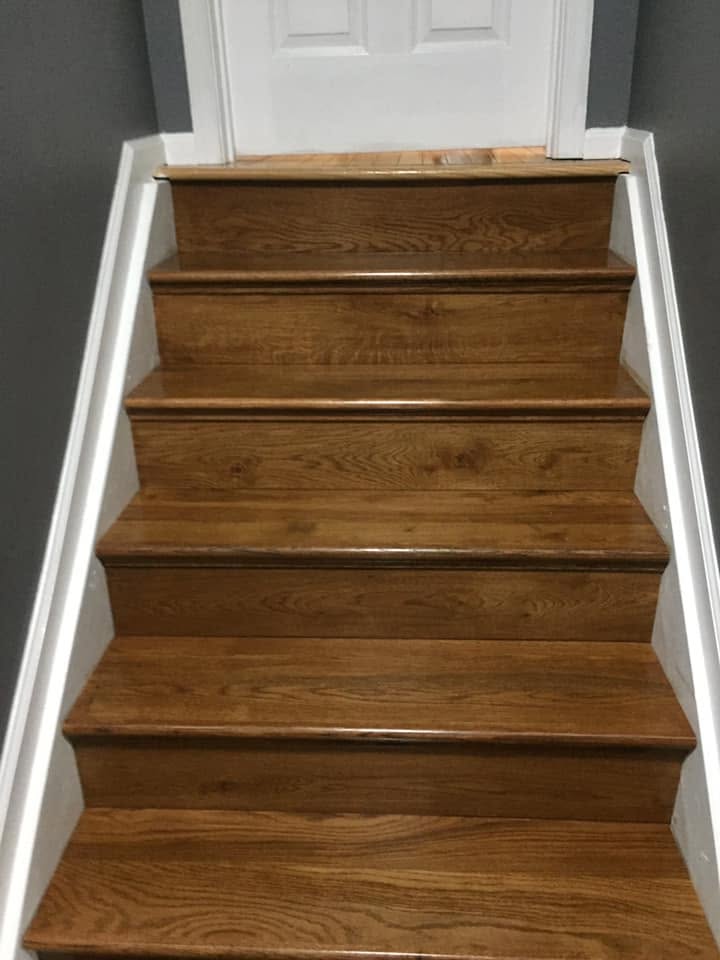 Sanded oak stair treads leading up a staircase, prepped for stain or a clear coat