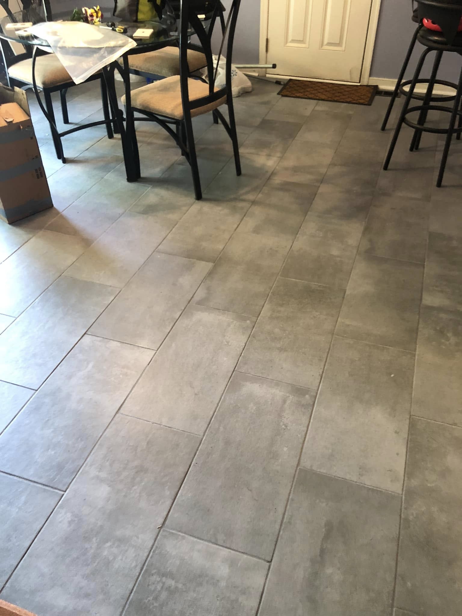 Grey concrete-look plank tile laid through a kitchen and dining space